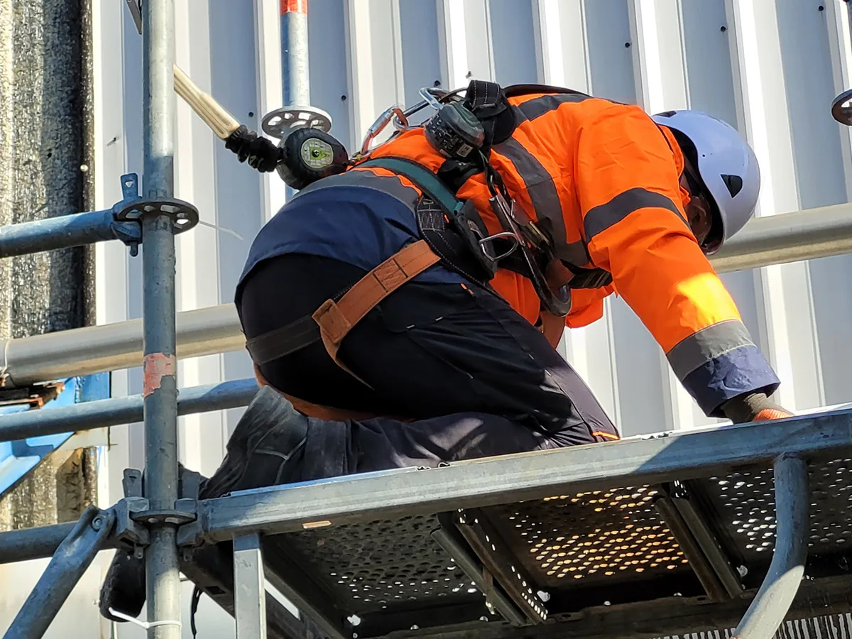 equipier sur un echafaudage suspendu - chantier calorifugeage